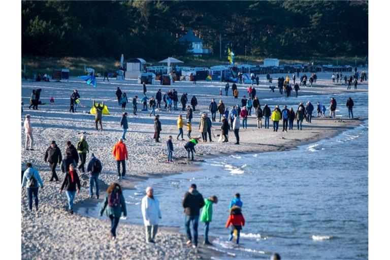 Touristen am Strand vor der Seebrücke im Ostseebad Binz. Foto: Stefan Sauer/dpa
