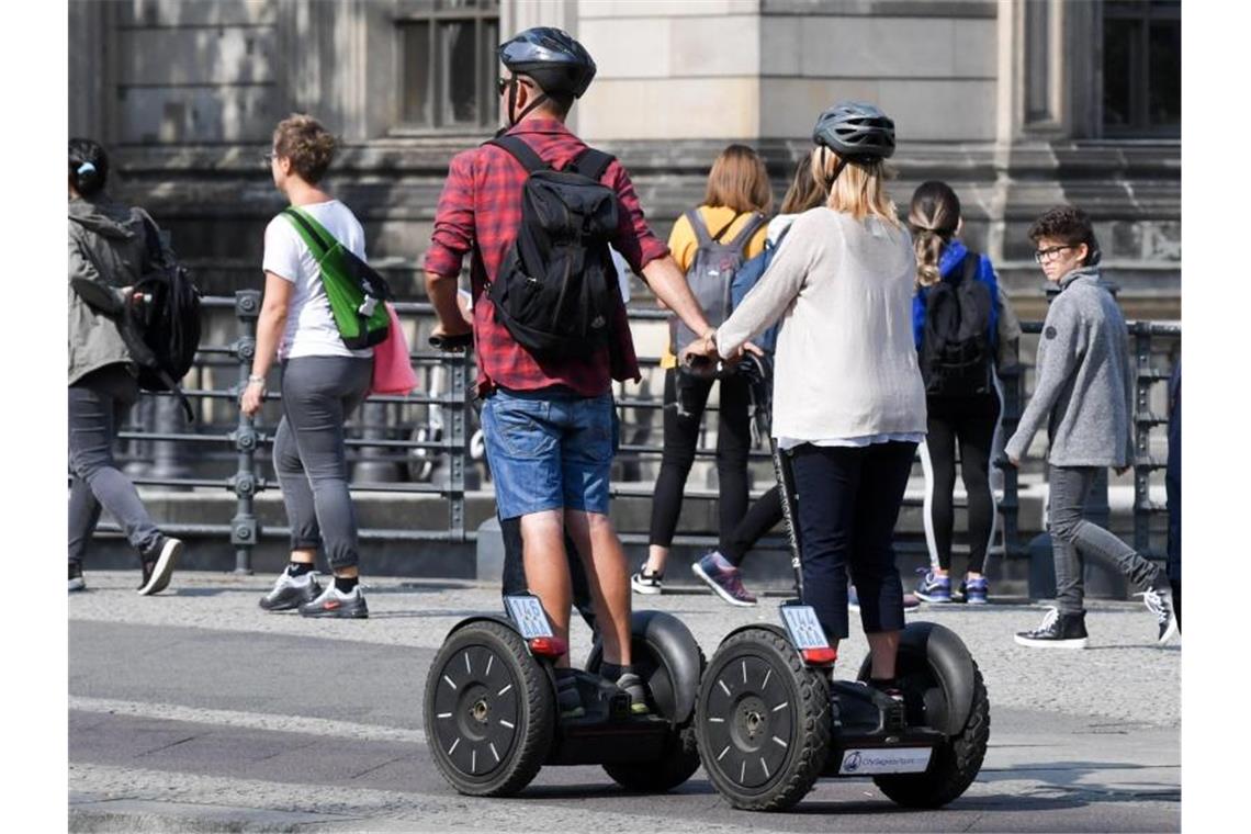 Touristen fahren mit Segways durch Berlin-Mitte. Foto: Jens Kalaene/dpa