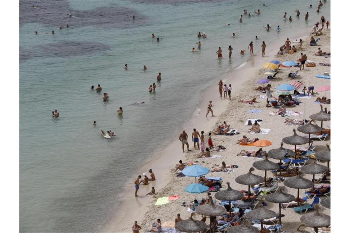 Tui: Positiver Buchungstrend hält an Touristen genießen an einem Strand bei Puerto Portals auf Mallorca die Sonne und das Meer. Foto: Clara Margais/dpa