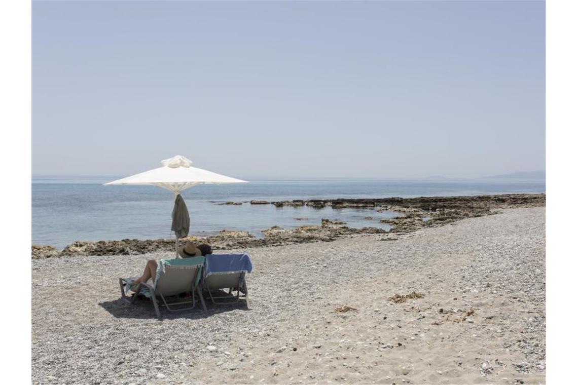 Touristen genießen den Ritsa-Strand in Kardamyli, einer Stadt am Meer fünfunddreißig Kilometer südöstlich von Kalamata, Peloponnes. Foto: Socrates Baltagiannis/dpa