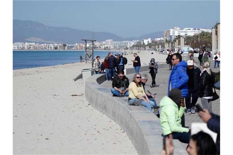 Touristen genießen die Februarsonne auf Mallorca. Die Insel bereitet sich auf die Saison vor. Foto: Clara Margais/dpa