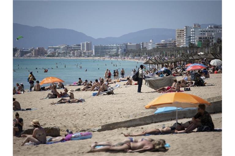 Touristen genießen die Sonne auf Mallorca. Foto: Francisco Ubilla/AP/dpa