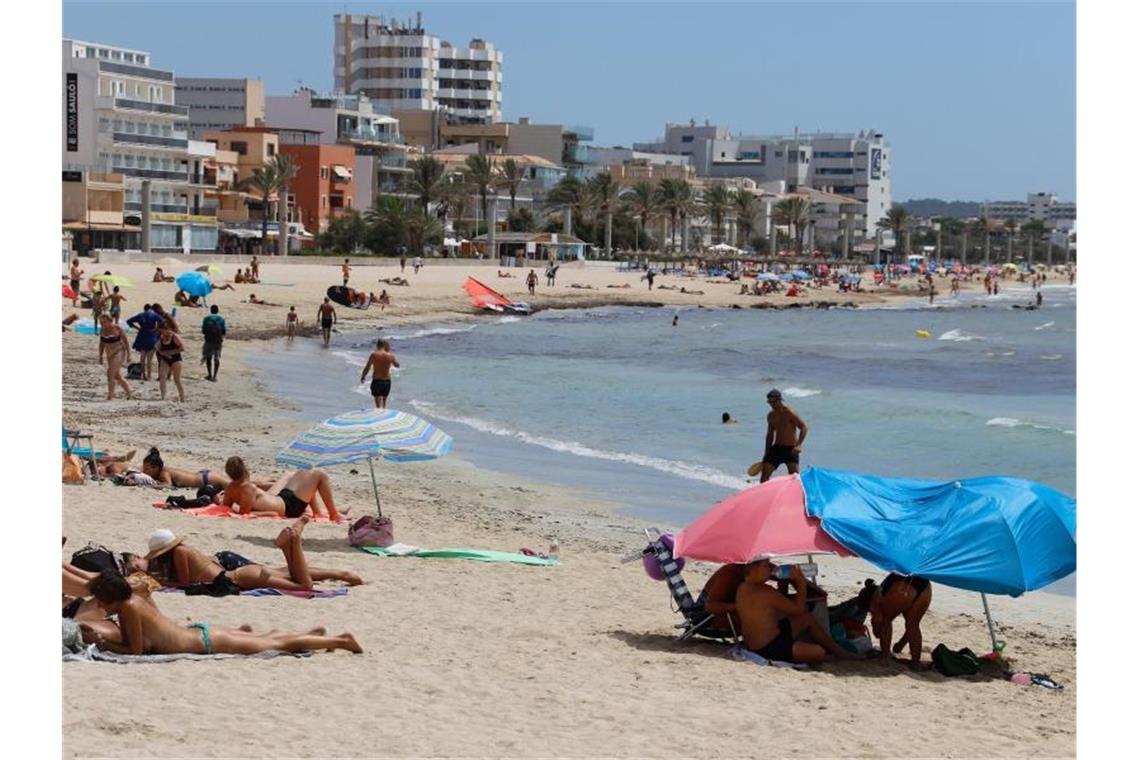Touristen genießen die Sonnen am Strand Can Pastilla auf der Insel Mallorca. Foto: Clara Margais/dpa