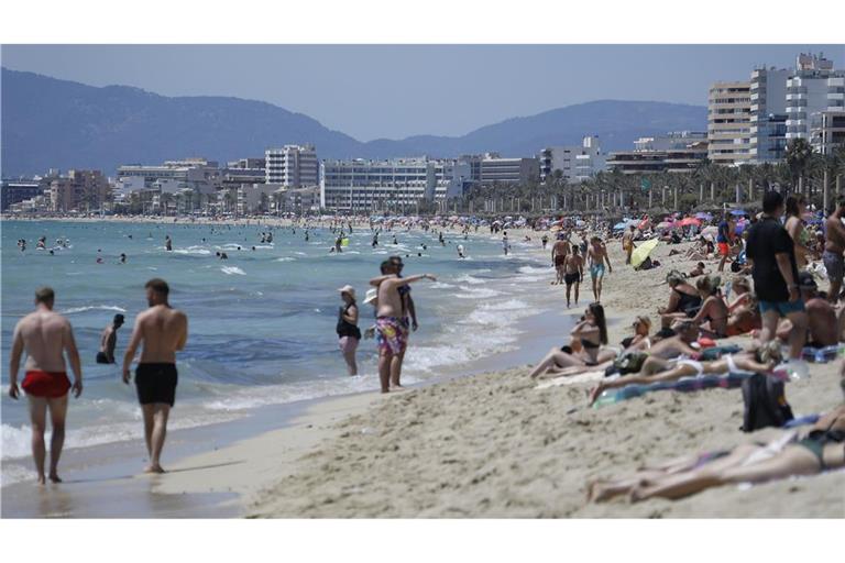 Touristen halten sich am Strand von Arenal in Palma de Mallorca auf. Ein neuer Plan in Palma könnte spürbare Auswirkungen auch für deutsche Touristen haben (Archivfoto).