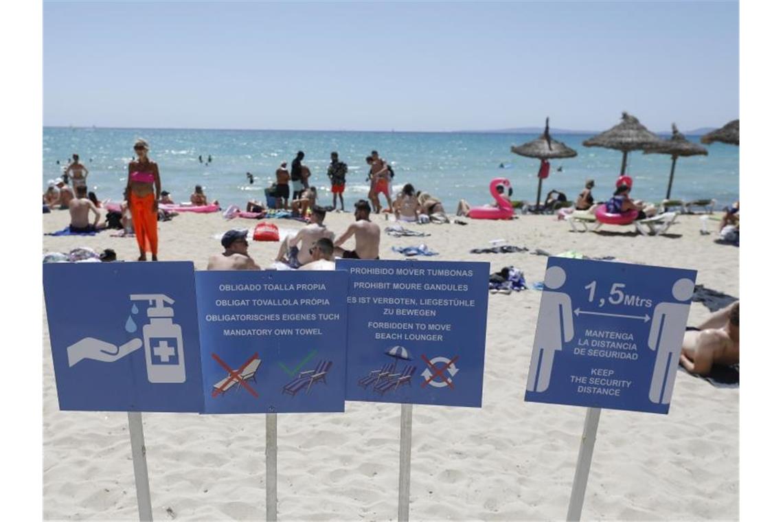 Touristen halten sich am Strand von Arenal in Palma de Mallorca auf. Foto: Clara Margais/dpa