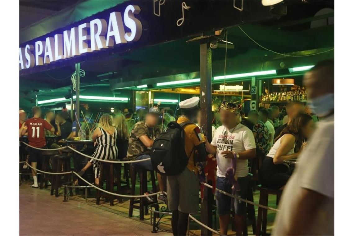 Touristen halten sich in der Bar "Las Palmeras" in der Bierstraße in el Arenal in Palma de Mallorca auf. Foto: Clara Margais/dpa