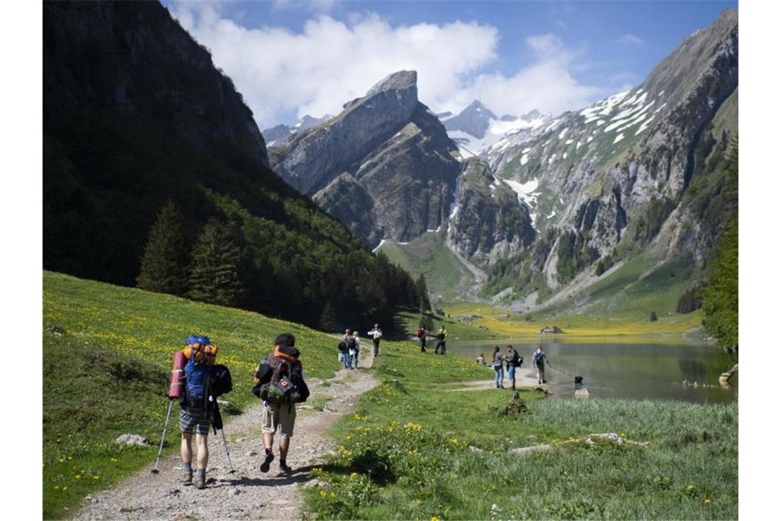Touristen sind unterwegs am Seealpsee, einem beliebten Ausflugsziel im Alpstein-Gebirge. Foto: Gian Ehrenzeller/KEYSTONE/dpa