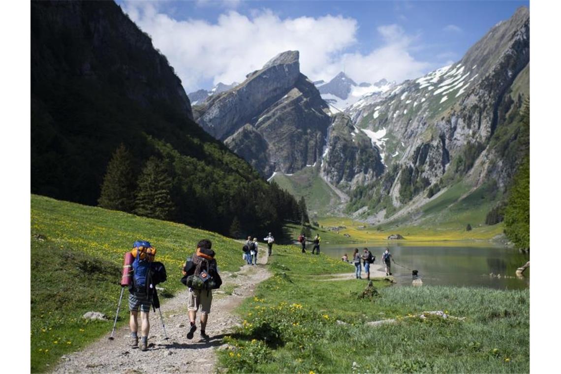 Feriengeschäft in der Schweiz boomt Touristen sind unterwegs am Seealpsee, einem beliebten Ausflugsziel im Alpstein-Gebirge. Foto: Gian Ehrenzeller/KEYSTONE/dpa