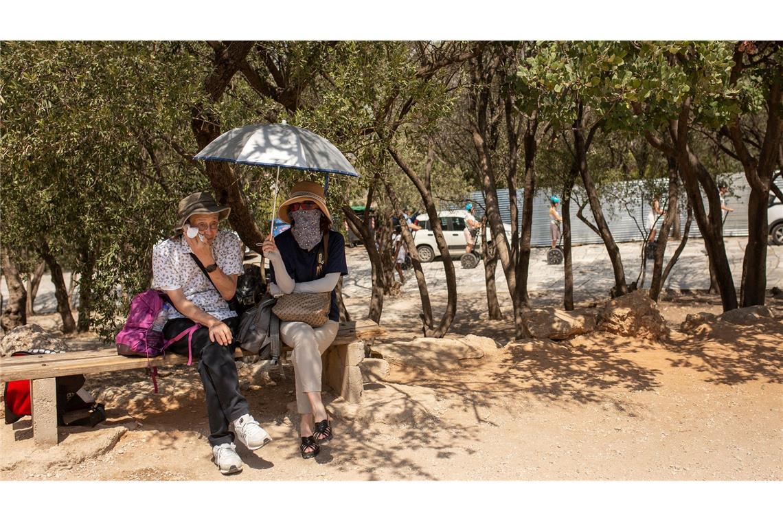Gesundheitsrisiko Klimawandel: WHO-Gremium soll Hilfe bieten Touristen sitzen unter Bäumen am Eingang der Akropolis in Athen.