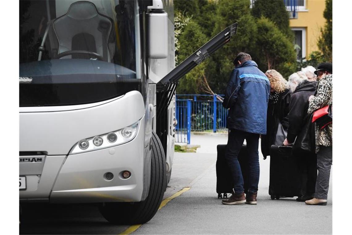 Staatsministerium: Reisebusverkehr bald wieder möglich Touristen stehen an einem Reisebus. Foto: Stefan Sauer/dpa-Zentralbild/dpa/Symbolbild
