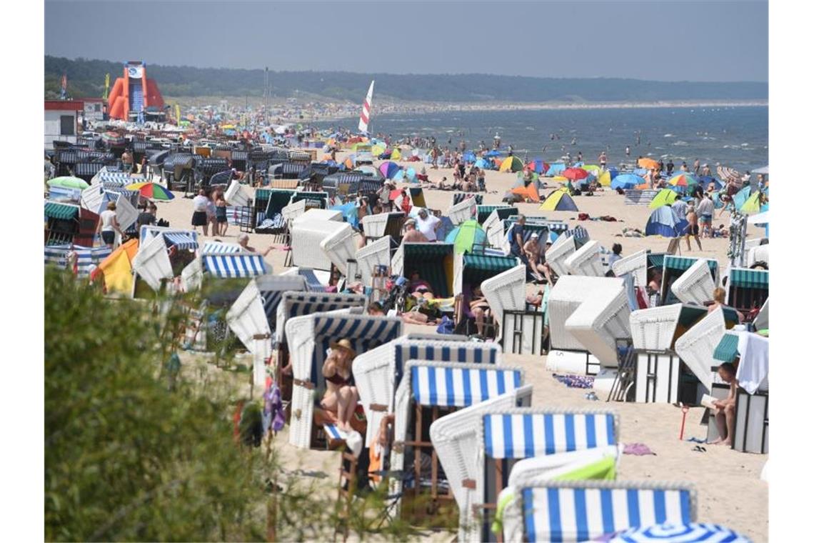 Touristen strömen bei hochsommerlichem Wetter an den Strand auf der Insel Usedom. Foto: Stefan Sauer/dpa