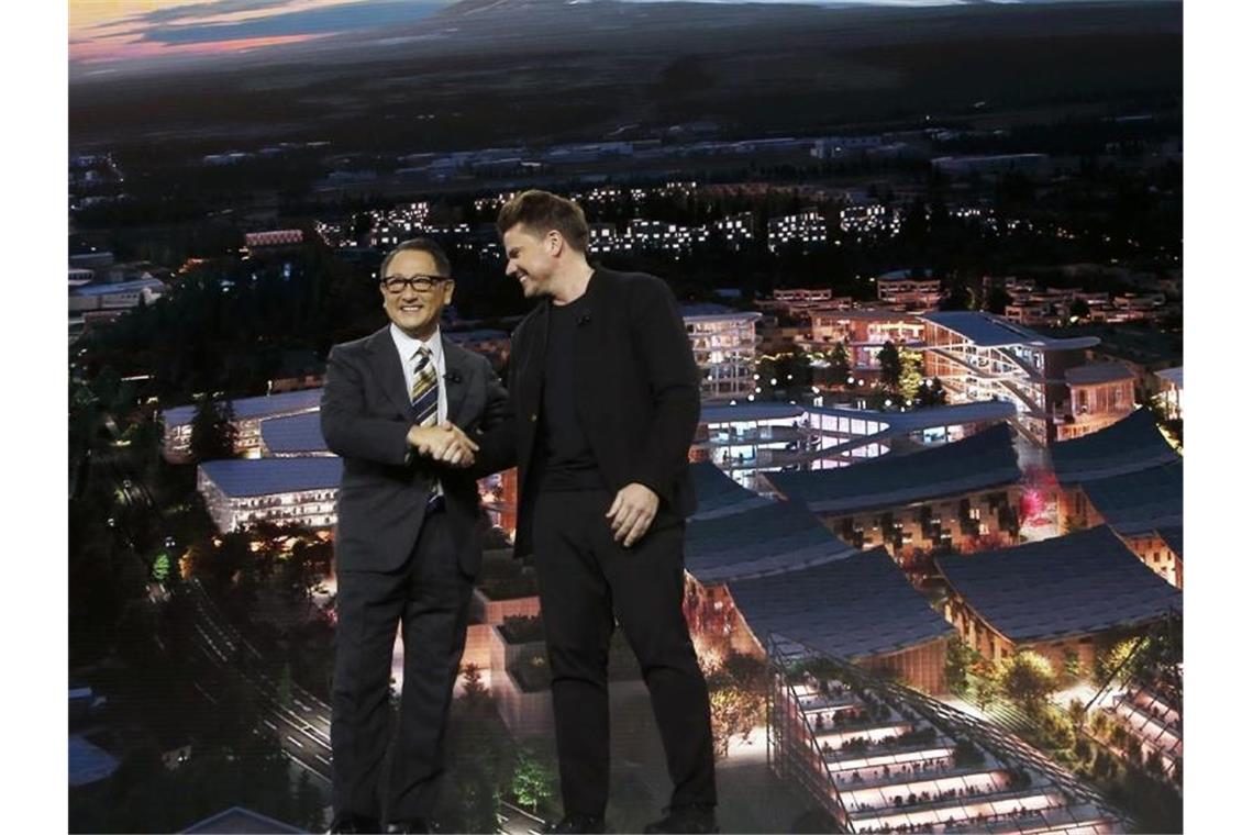 Toyota-Chef Akio Toyoda zusammmen mit dem dänischen Architekten Bjarke Ingels auf der Technik-Messe CES. Foto: Ross D. Franklin/AP/dpa