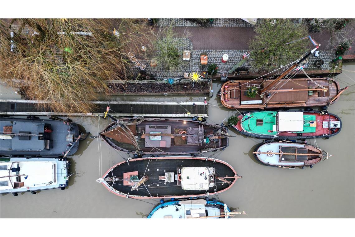 Traditionsschiffe liegen im grauen Wasser im Hafen von Leer.