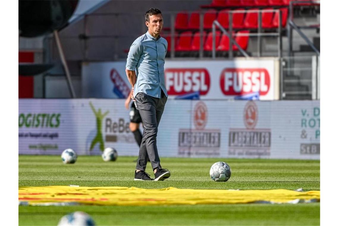 Trainer Christian Eichner von Karlsruhe steht vor einem Spiel im Stadion. Foto: Armin Weigel/dpa/Archivbild