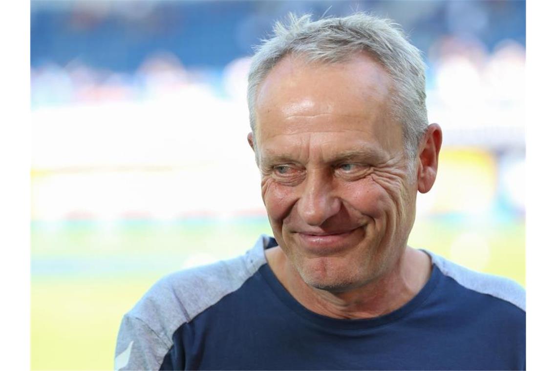 Trainer Christian Streich aus Freiburg lächelt vor Spielbeginn. Foto: Friso Gentsch/Archivbild