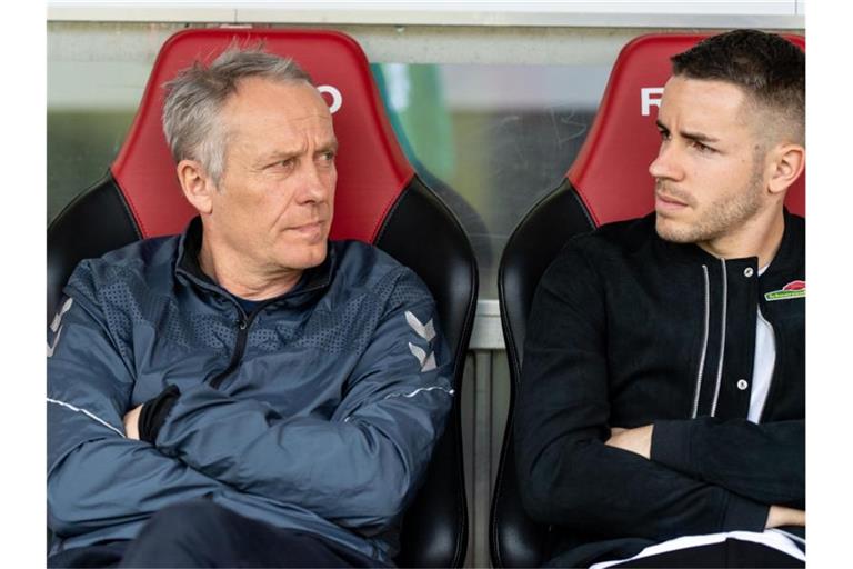 Trainer Christian Streich (l) von Freiburg und Christian Günter (r) sitzen auf der Bank. Foto: Patrick Seeger/dpa