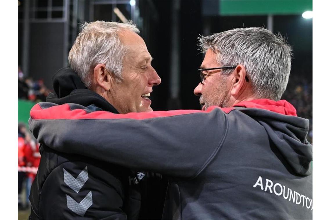 Trainer Christian Streich von Freiburg (l.) umarmt Trainer Urs Fischer von Berlin (r.). Foto: Patrick Seeger/dpa