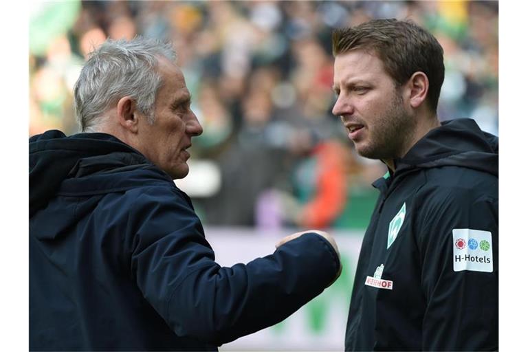 Trainer Florian Kohfeldt (r) von Werder unterhält sich vor einem Spiel mit Trainer Christian Streich von Freiburg. Foto: Carmen Jaspersen/dpa/Archivbild