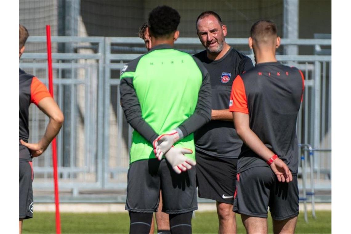 Trainer Frank Schmidt (2.v.r) spricht zu seinen Spielern vom Zweitligisten FC Heidenheim. Foto: Stefan Puchner/dpa/Archivbild