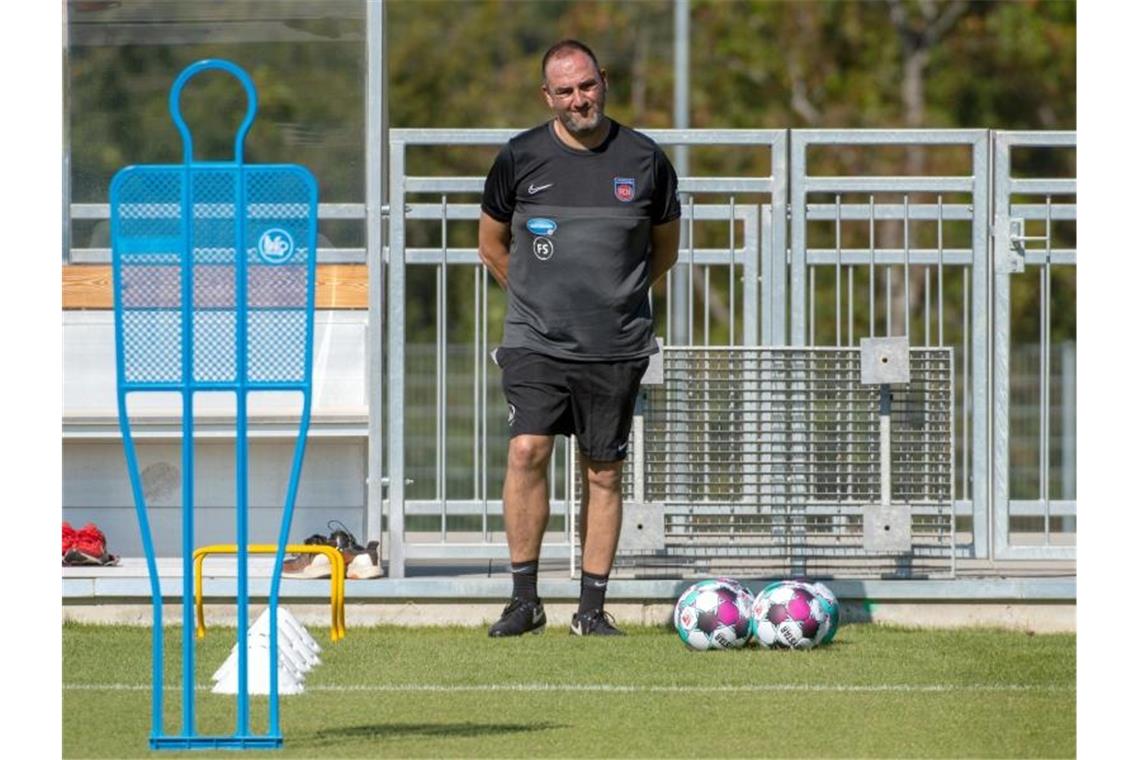 Trainer Frank Schmidt steht beim Trainingsauftakt des Zweitligisten FC Heidenheim neben Bällen. Foto: Stefan Puchner/dpa/Archivbild