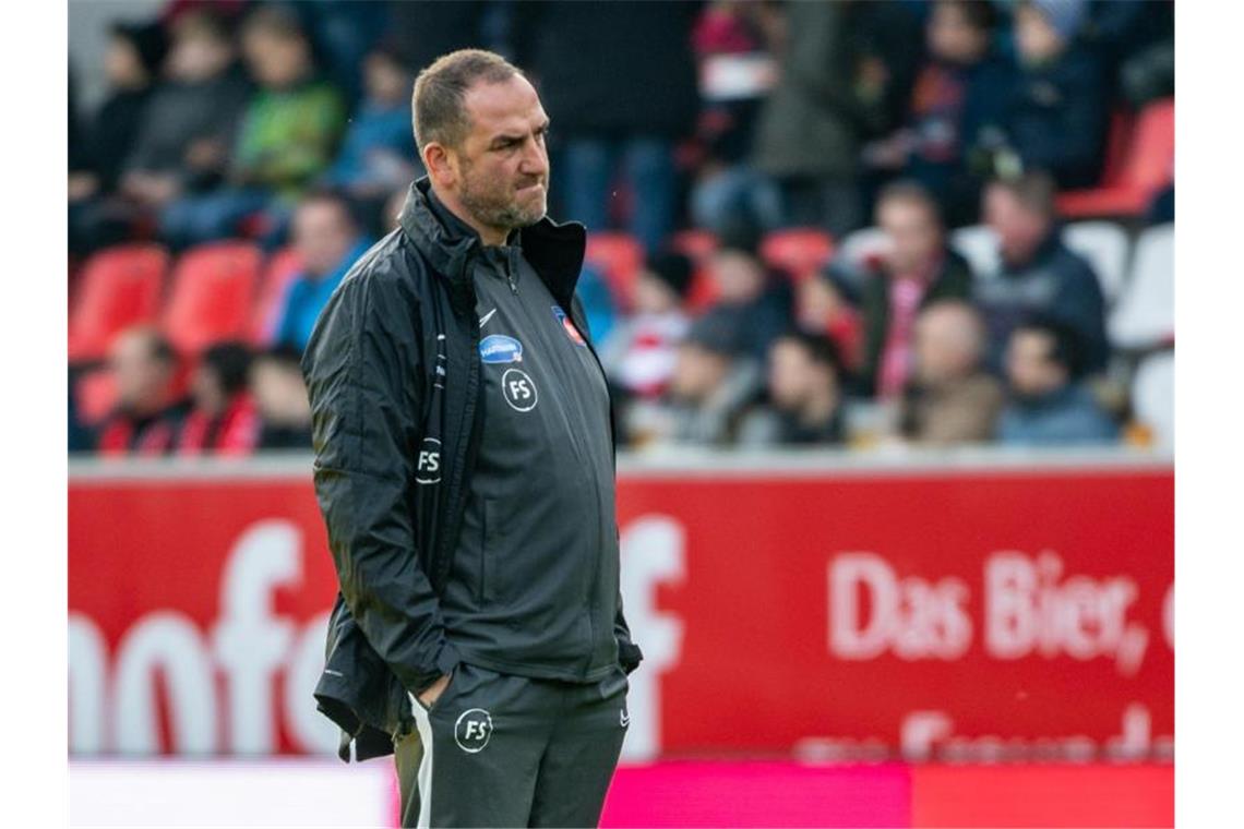 Trainer Frank Schmidt von Heidenheim steht vor einem Spiel im Stadion. Foto: Armin Weigel/dpa