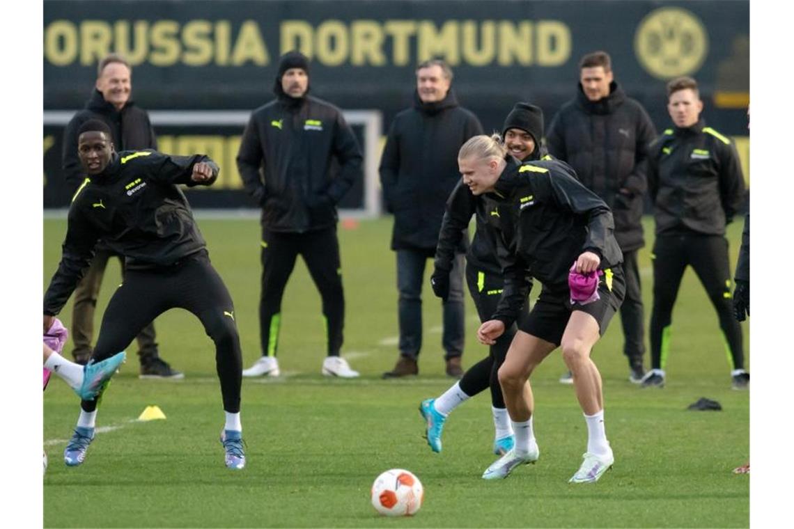 Trainer Marco Rose (hinten,M) verfolgt das BVB-Abschlusstraining, an dem auch der verletzte Erling Haaland (vorn,r) teilnimmt. Foto: Bernd Thissen/dpa