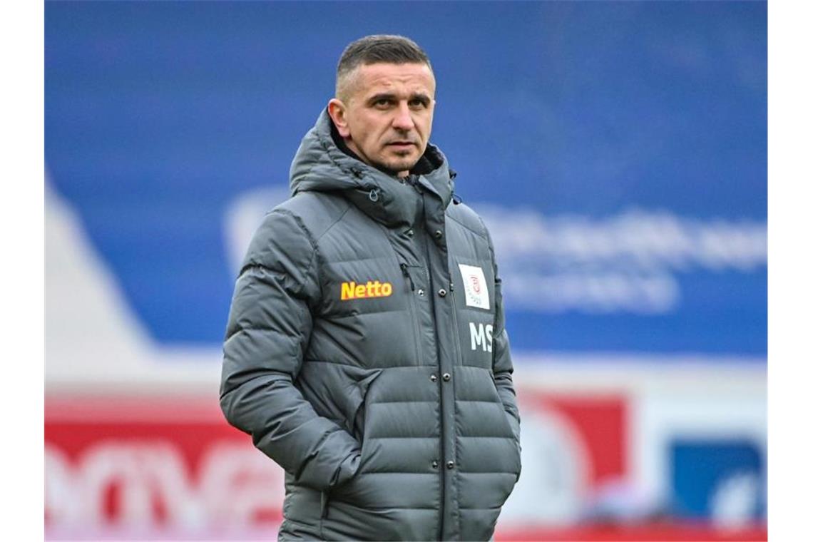 Trainer Mersad Selimbegovic von Regensburg steht vor einem Spiel im Stadion. Foto: Armin Weigel/dpa/Archivbild