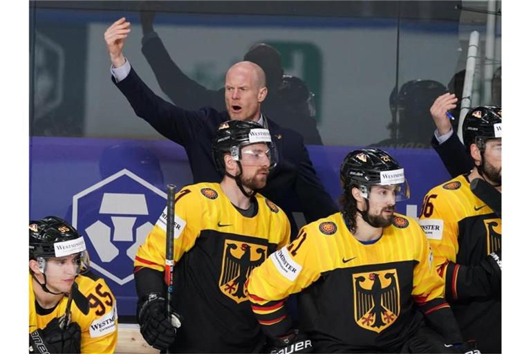 Trainer Toni Söderholm (hinten, links) und das DEB-Team sind gegen die USA gefordert. Foto: Roman Koksarov/dpa