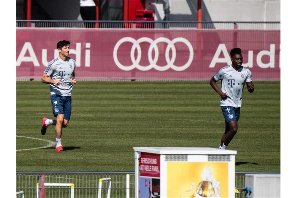 Training mit Abstand: Die Bayern-Profis Robert Lewandowski (l) und Alphonso Davies. Foto: Matthias Balk/dpa