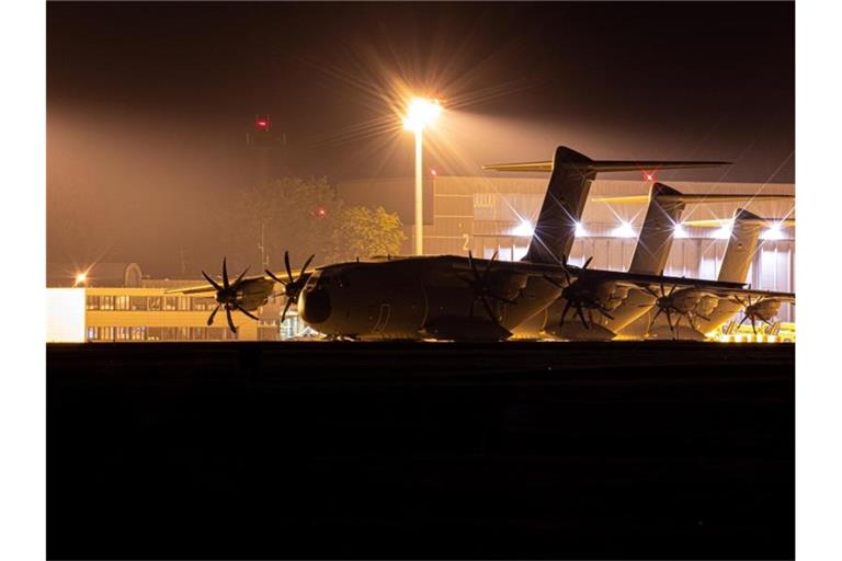 Transportflugzeuge vom Typ Airbus A400M der Luftwaffe stehen am Abend auf dem Fliegerhorst Wunstorf in der Region Hannover hinter einem Zaun. Foto: Moritz Frankenberg/dpa