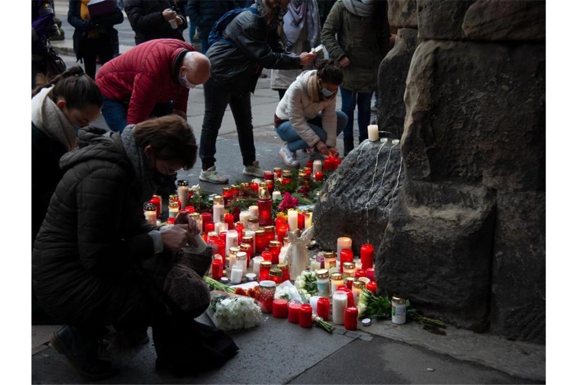 Trauernde legen am Morgen nach der Amokfahrt mit fünf Toten in Trier an der Porta Nigra Kerzen und Blumen nieder. Foto: Harald Tittel/dpa