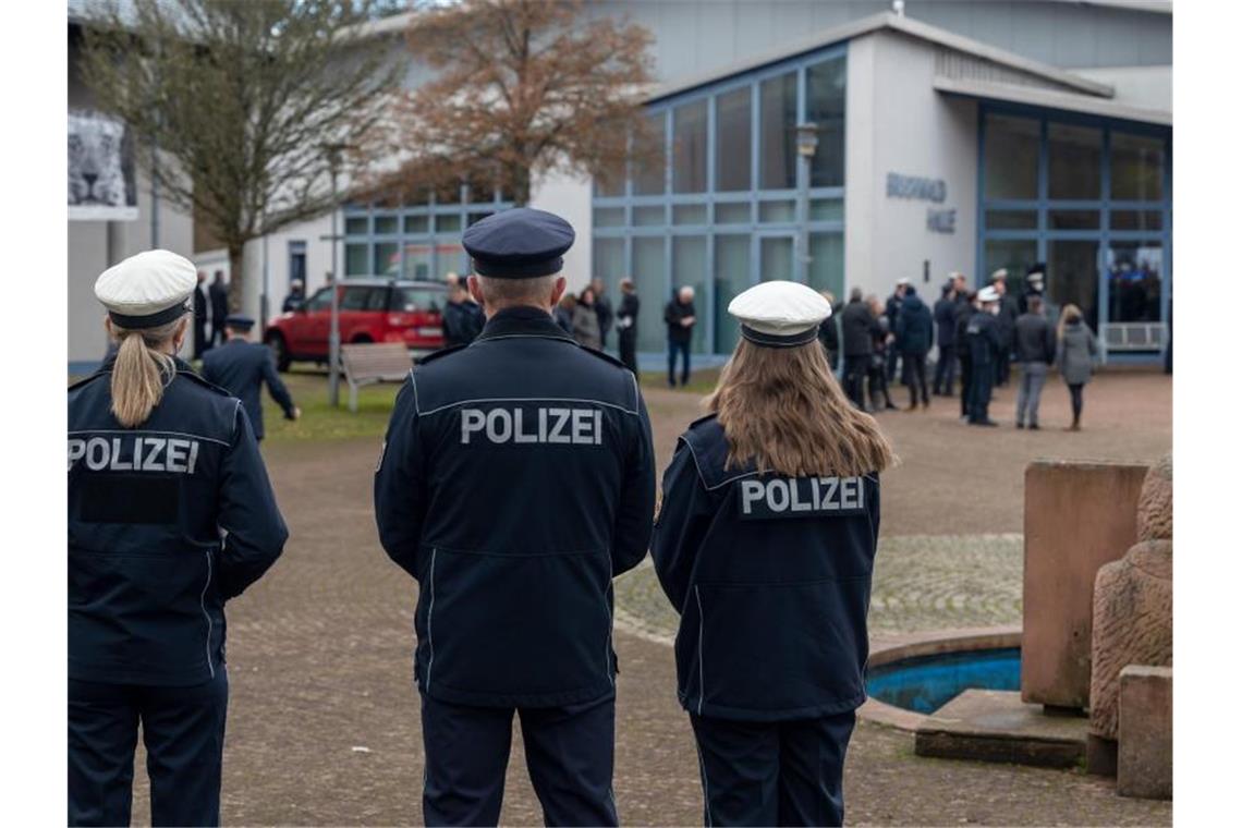 Trauernde Polizisten vor der Bruchwaldhalle in Freisen. Foto: Harald Tittel/dpa