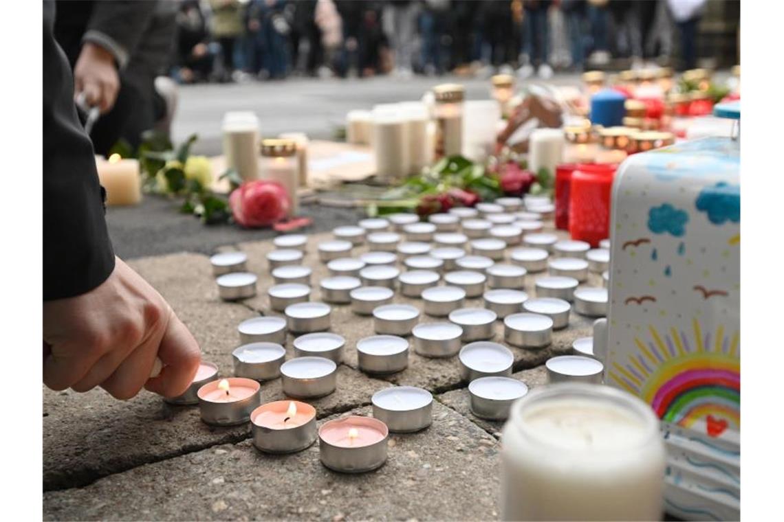 Trauernde zünden nach der Amokfahrt mit fünf Toten in Trier an der Porta Nigra Kerzen an. Zahlreiche Menschen gedenken hier der Opfer der Amokfahrt eines 51-jährigen Mannes durch die Innenstadt. Foto: Harald Tittel/dpa