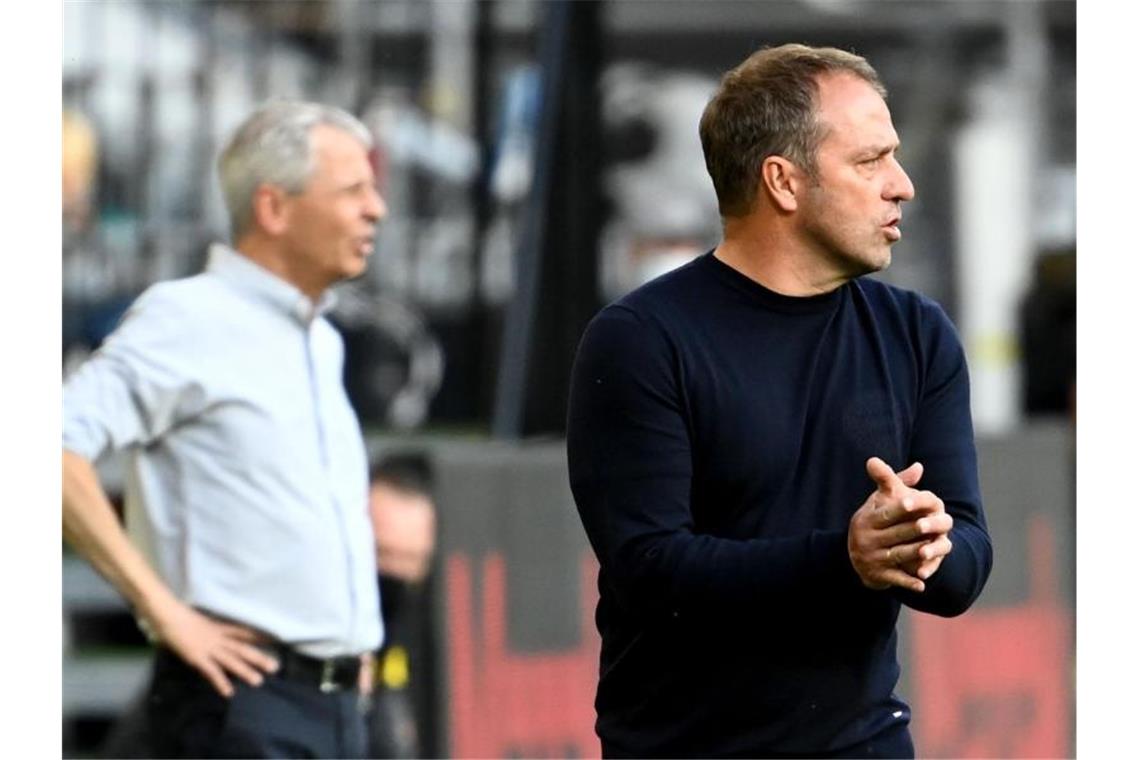 Treffen im Bundesliga-Gipfel mit ihren Teams aufeinander: Bayern-Coach Hansi Flick (r) und Dortmunds Lucien Favre. Foto: Federico Gambarini/dpa-Pool/dpa