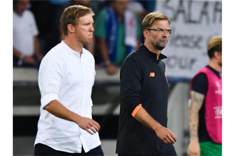 Treffen mit ihren Teams in Budapest aufeinander: Leipzig-Coach Julian Nagelsmann (l) und Liverpools Jürgen Klopp. Foto: picture alliance / Uwe Anspach/dpa