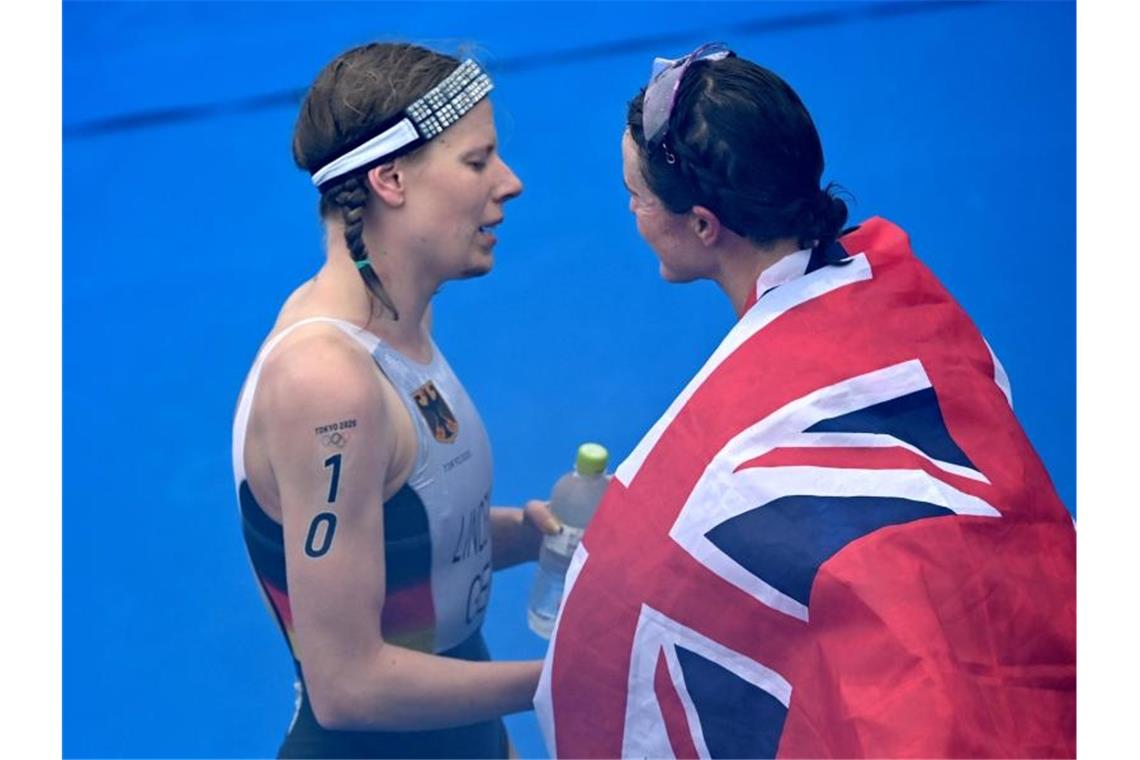 Das war die Olympia-Nacht Triathletin Laura Lindemann gratuliert Flora Duffy zum Sieg Olympiasieg. Foto: Sebastian Gollnow/dpa
