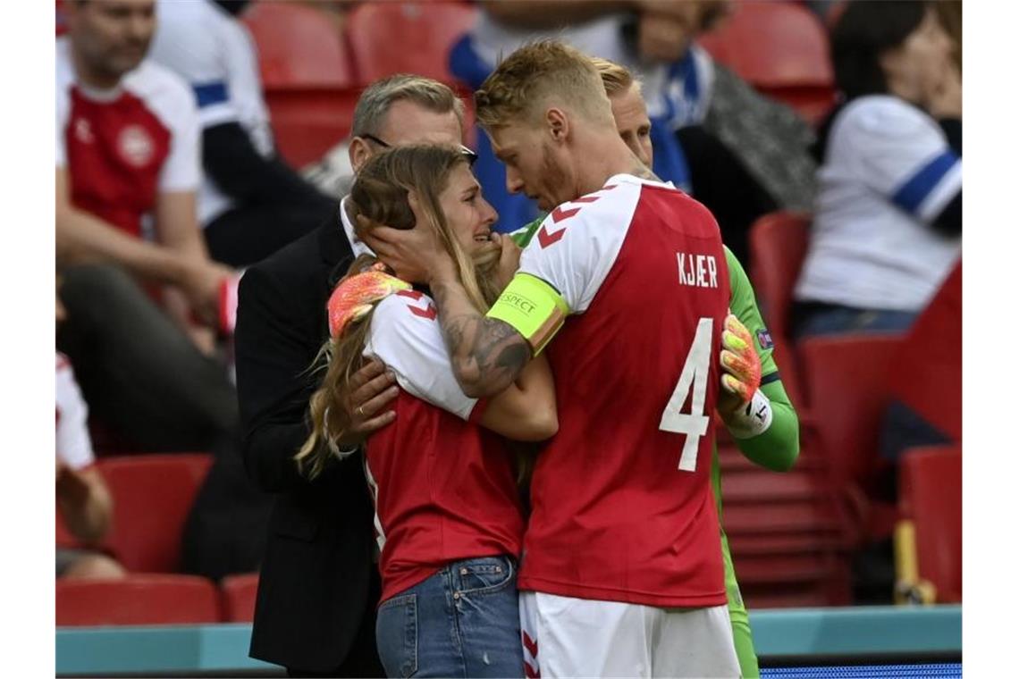 Helfer, Tröster, Freund: Dänemarks Kjaer als Held gefeiert Tröstender Kapitän: Simon Kjaer (r) kümmert sich um die heraneilende Freundin von Christian Eriksen. Foto: Stuart Franklin/Getty Pool/AP/dpa
