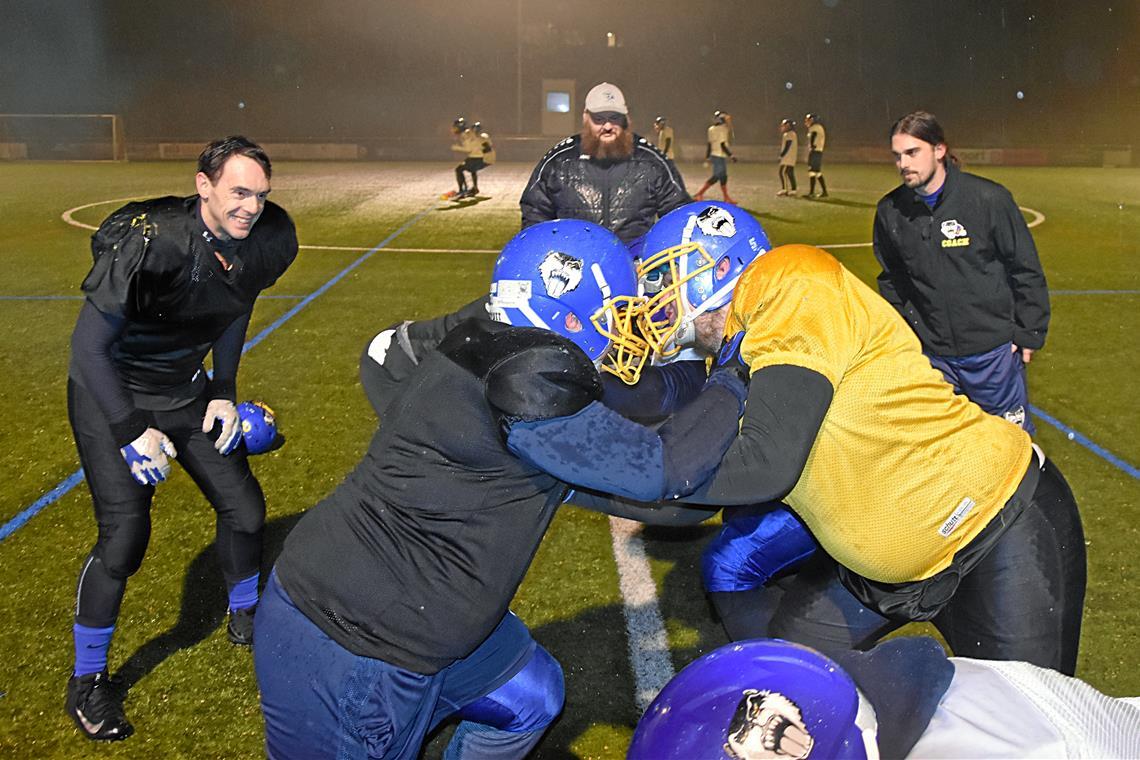 Die Backnang Wolverines erhöhen die Aussichten auf Erfolgserlebnisse Trotz des widrigen Wetters zeigen die Footballer der Backnang Wolverines im Training vollen Einsatz. Das gefällt Defensive Coordinator Martin Häuser, Offensive Line Coach Oliver Jauß und Offensive Coordinator Jan Kneiser (hinten von links). Foto: Tobias Sellmaier