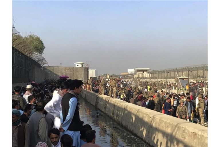 Trotz einiger Zeichen der Entspannung am Flughafen der afghanischen Hauptstadt Kabul harren dort weiterhin Tausende verzweifelte Menschen bei großer Hitze und teils chaotischem Gedränge aus. Foto: XinHua/dpa