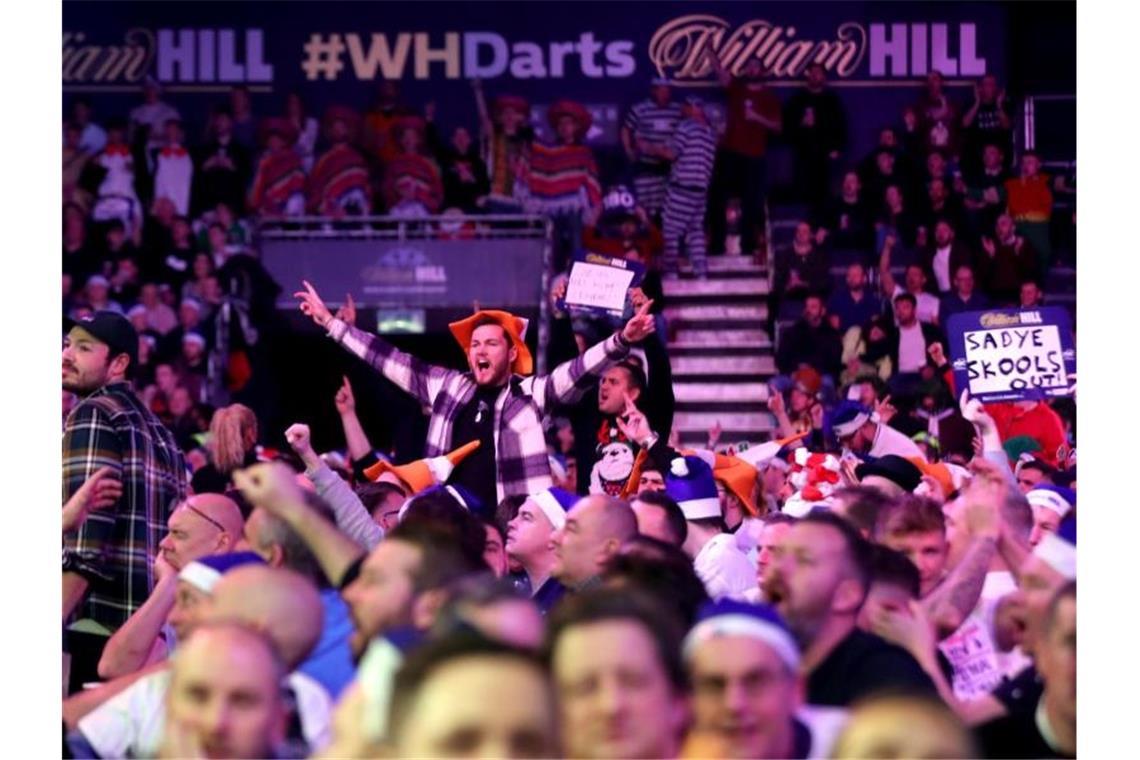 Pfeilelotto mit Omikron-Chancen: Darts-WM immer skurriler Trotz Omikron: Die Fans feiern bei der Darts-WM in London eine wilde Party. Foto: Bradley Collyer/PA Wire/dpa