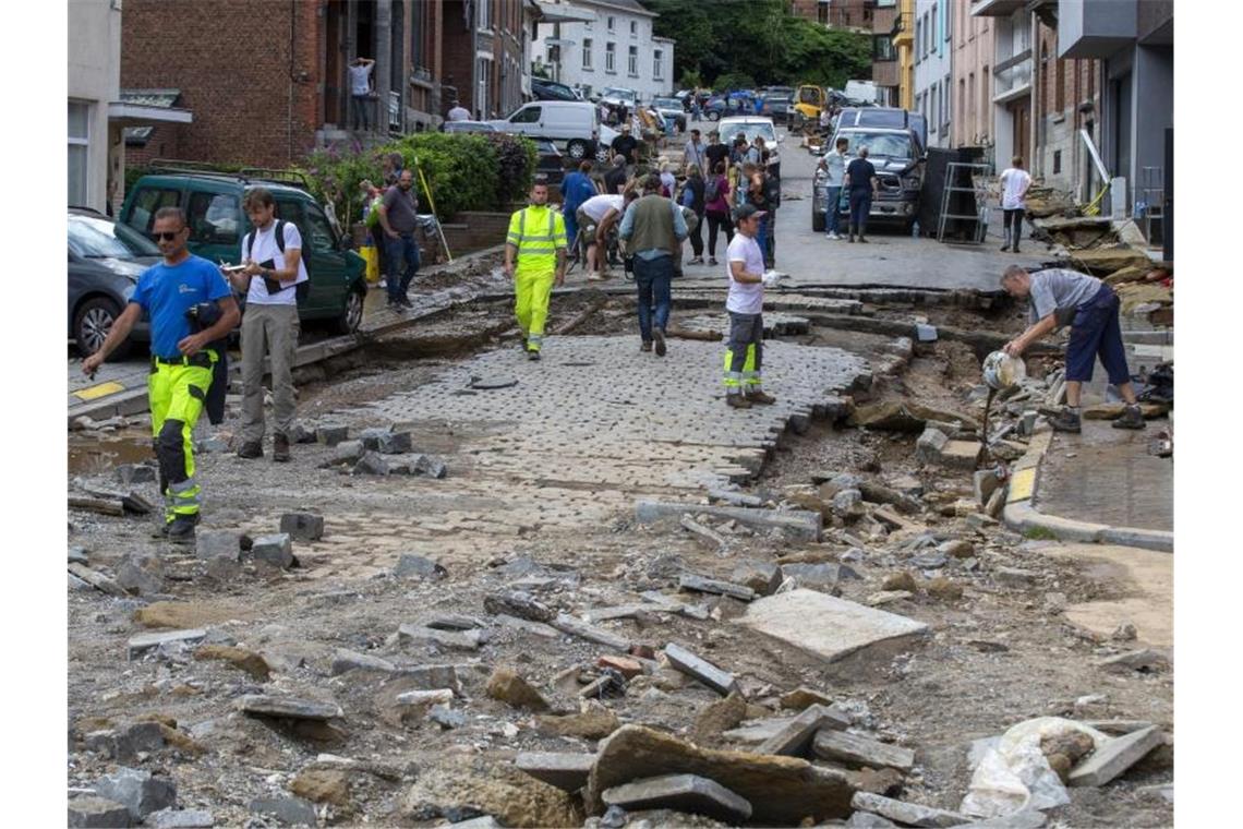 Trümmer liegen auf der zerstörte Straße Rue Andre Sodar in der Nähe eines Bahnübergangs im Stadtzentrum von Dinant. Foto: Nicolas Maeterlinck/BELGA/dpa