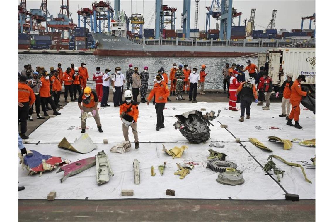 Trümmerteile, die in den Gewässern um die Absturzstelle des Passagierflugzeugs der Sriwijaya Air gefunden wurden, werden im Hafen Tanjung Priok zur Inspektion ausgelegt. Foto: Dita Alangkara/AP/dpa