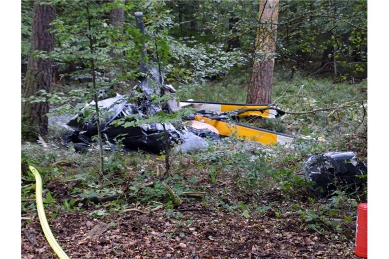 Trümmerteile eines Hubschraubers vom Typ Robinson R44 liegen in einem Wald bei Buchen in Baden-Württemberg. Foto: Julian Buchner/Einsatz-Report24/dpa