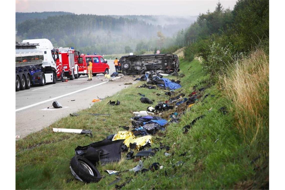 Trümmerteile liegen an der Unfallstelle neben der Autobahn 9, im Hintergrund liegt der umgestürzte Transporter. Foto: Bodo Schackow