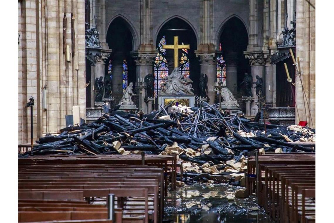 Trümmerteile und verkohlte Holzbalken im Inneren der Kathedrale. Foto: Christophe Petit Tesson/EPA POOL/AP/dpa