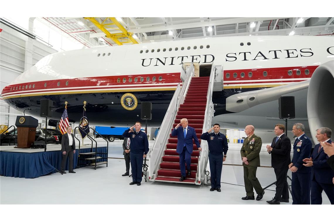 Trump salutiert auf der Gangway des geschenkten Flugzeugs.