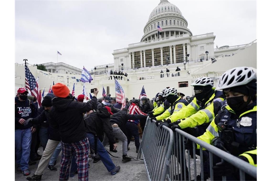 Trump-Unterstützer versuchen eine Absperrung vor dem Kapitol zu durchbrechen. Foto: John Minchillo/AP/dpa