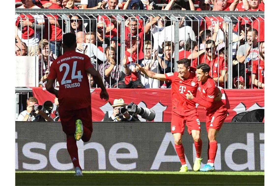 Trumpfte gegen den FC Köln groß auf: Robert Lewandowski (M) bejubelt mit Philippe Coutinho (r) und Corentin Tolisso einen Treffer. Foto: Angelika Warmuth