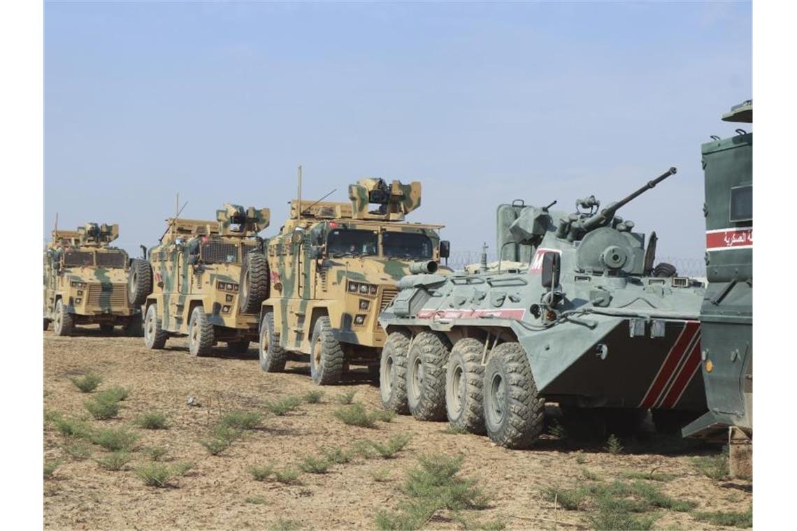 Türkische und russische Soldaten in Panzer und Militärfahrzeugen patroullieren an der türkisch-syrischen Grenze. Foto: Uncredited/AP/dpa