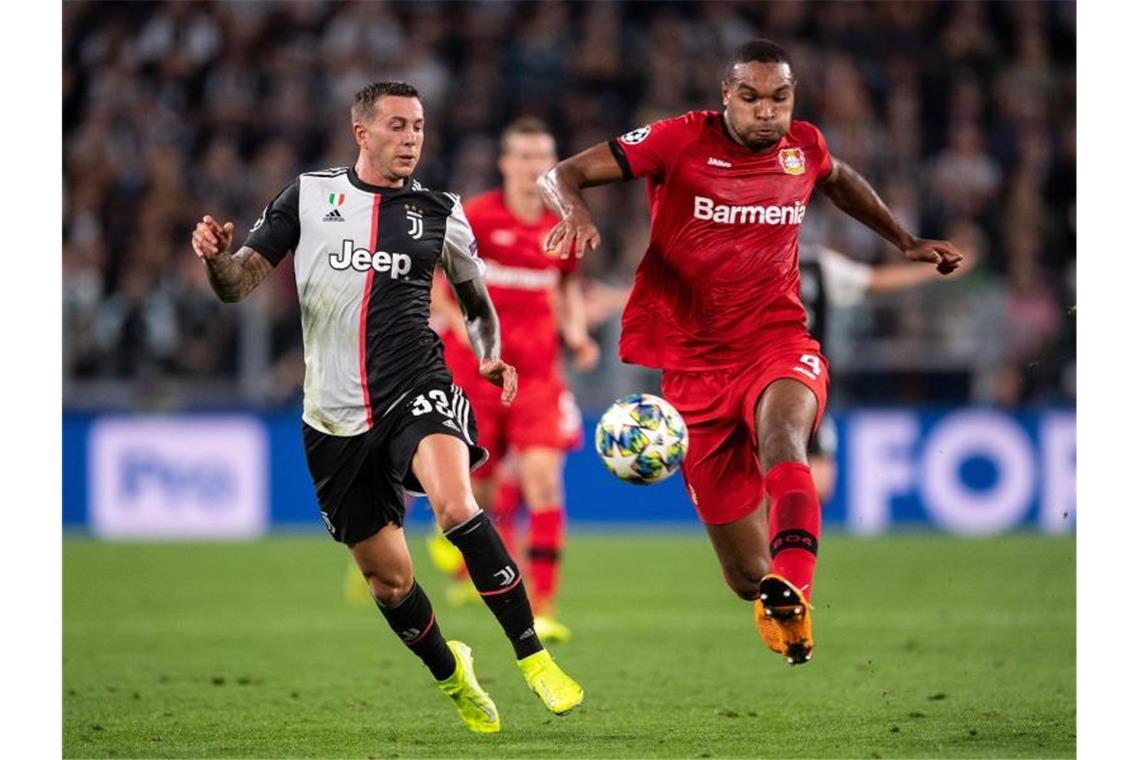 Turins Federico Bernardeschi (l) und Jonathan Tah von Bayer Leverkusen kämpfen um den Ball. Foto: Marius Becker/dpa